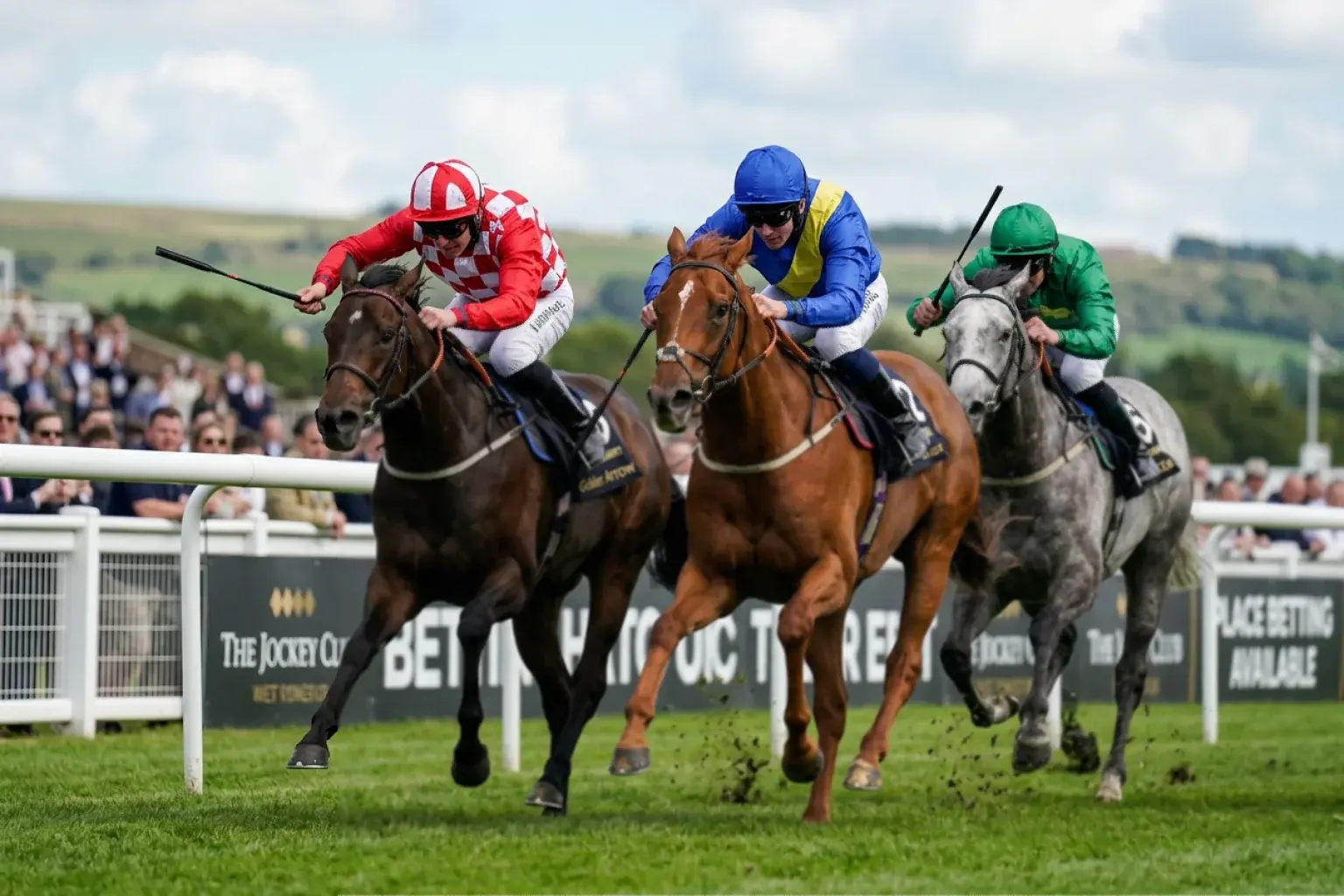 Close finish at a horse racing meeting with three runners competing for place positions